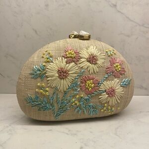 Rafe New York Straw Clutch with stone closure and floral details on the front.